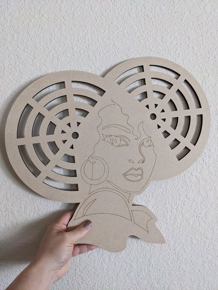 someone holding up a cut out of a woman's face