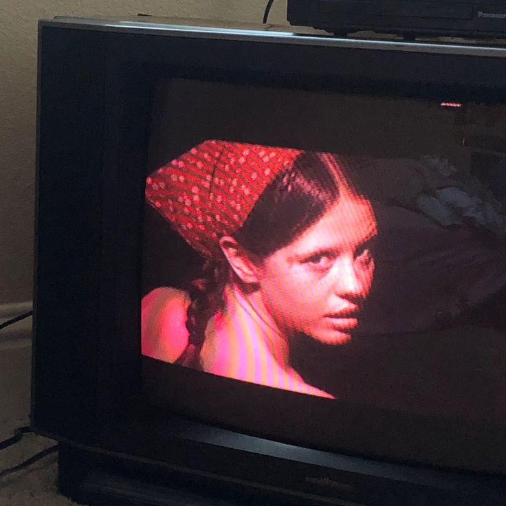 an old television with a young woman on the screen