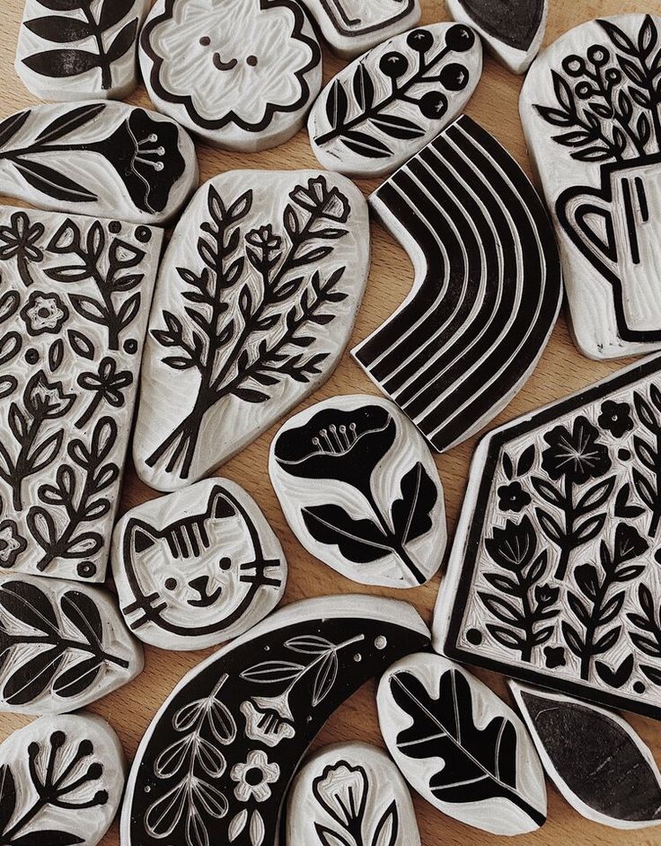 some black and white decorated cookies sitting on top of a wooden table next to each other