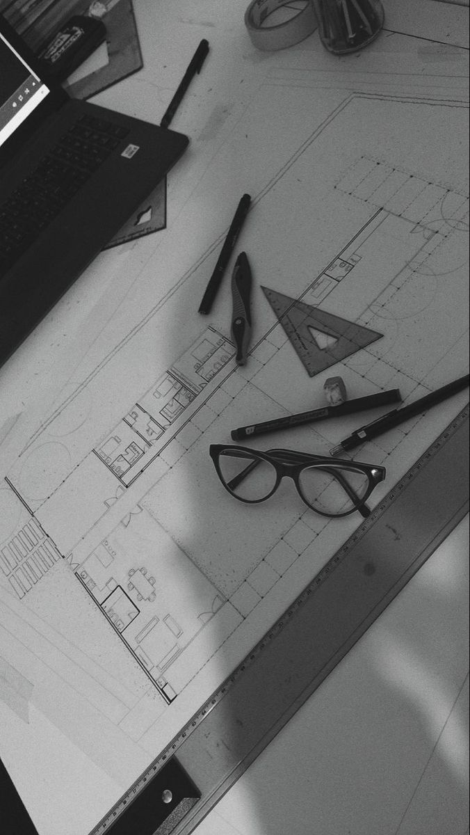 a table topped with glasses and pencils next to a laptop computer