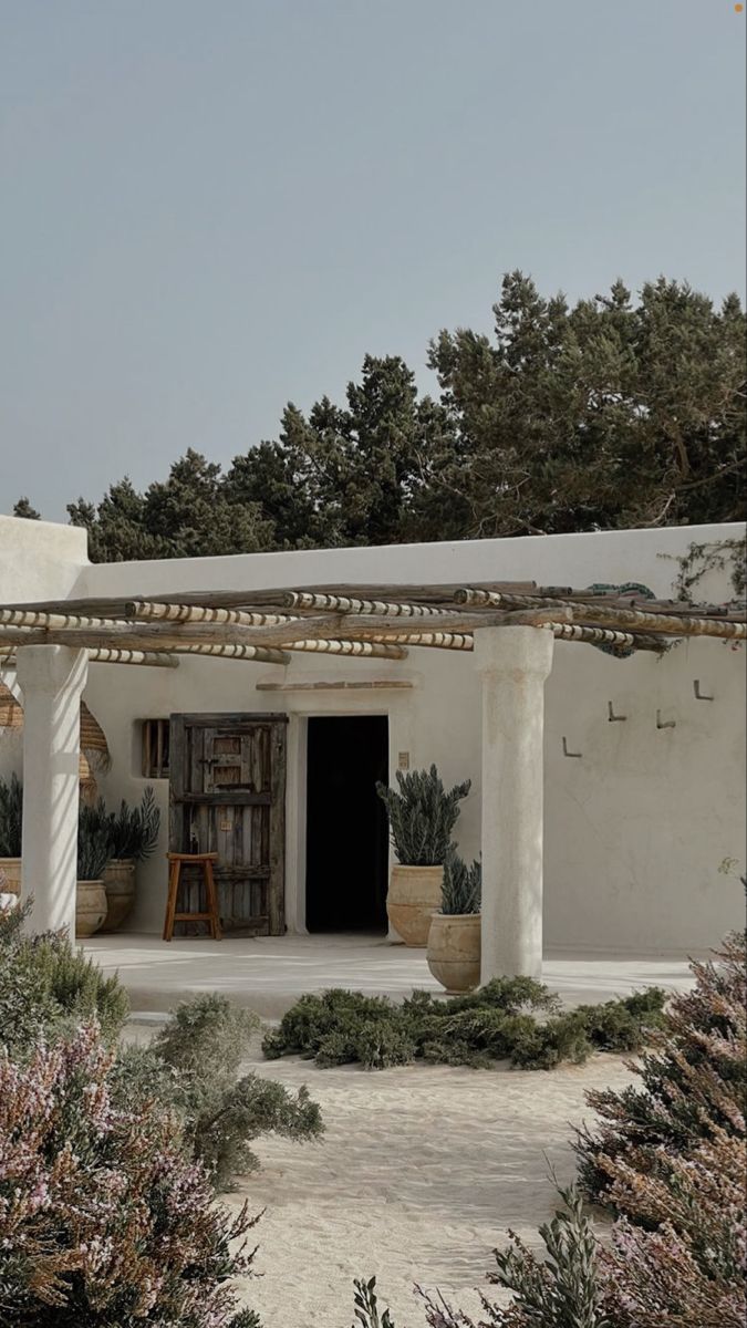 an adobe - style house with potted plants on the outside