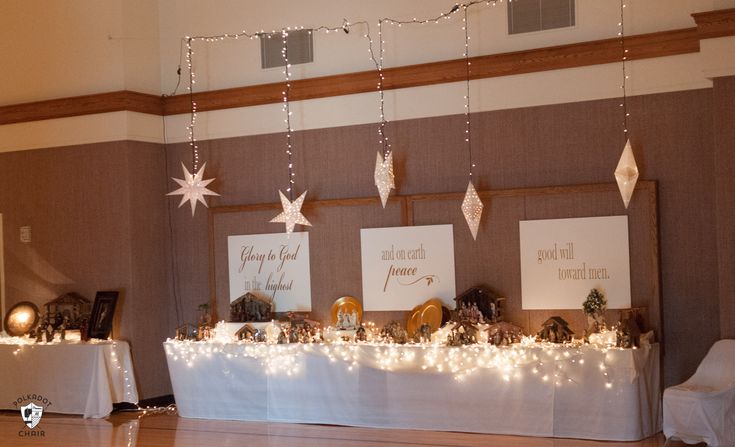 there is a table that has decorations on it and lights hanging from the ceiling above it