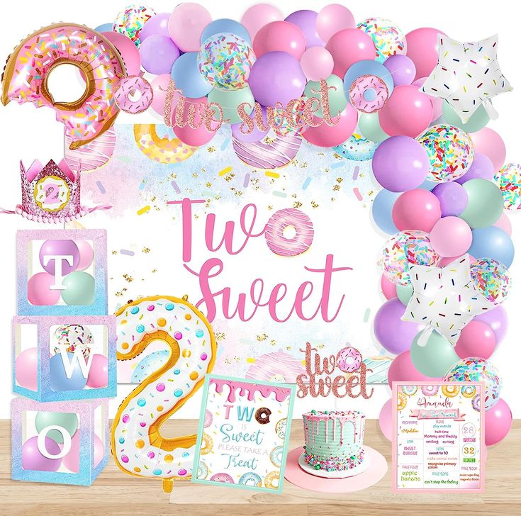 a birthday party with balloons, cake and decorations for two sweet 1st birthdays on a wooden table