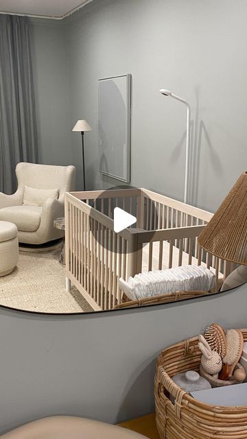 a baby's room is reflected in the mirror on the wall, with furniture and accessories