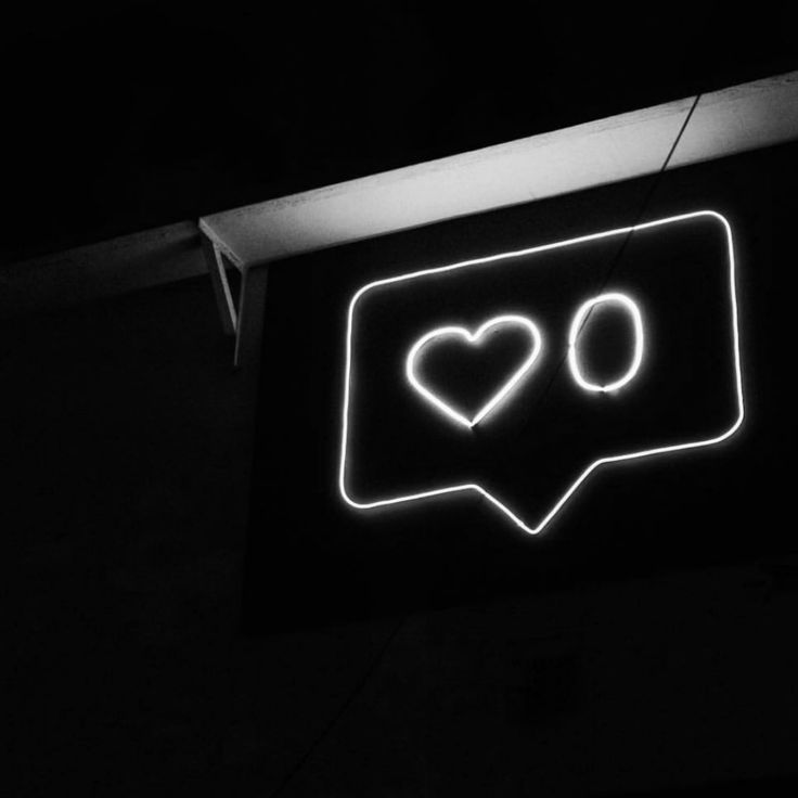 a black and white photo of a neon sign with two hearts in the speech bubble