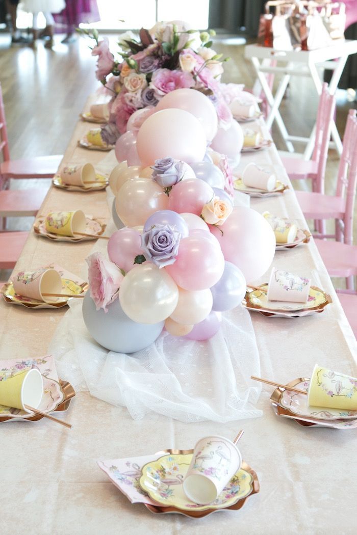 a long table with balloons and plates on it