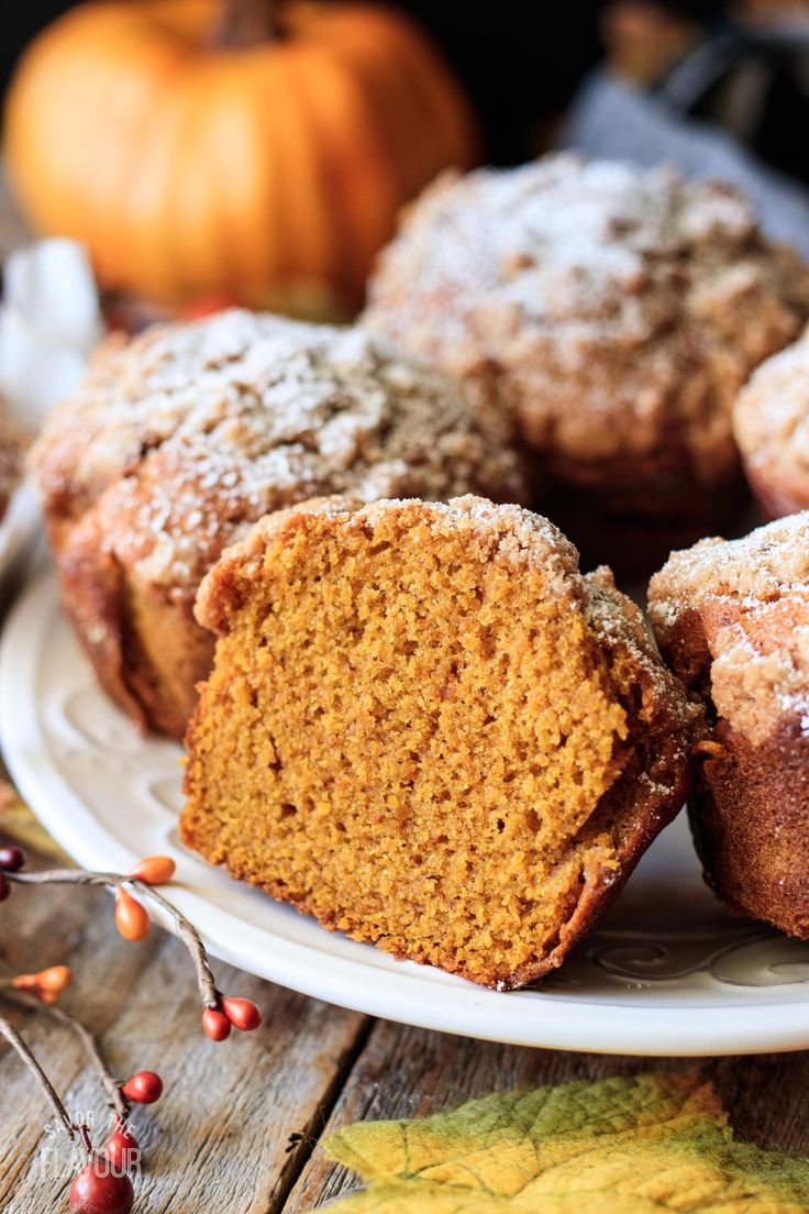 a white plate topped with muffins covered in powdered sugar