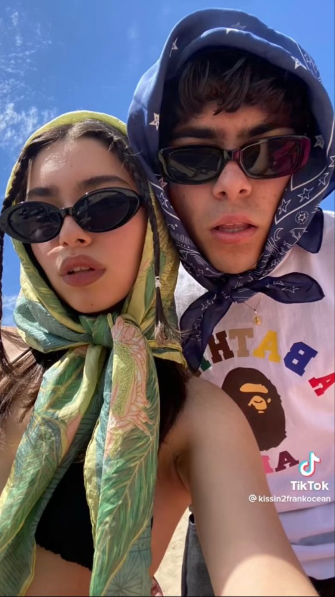 a man and woman taking a selfie on the beach with sunglasses on their heads