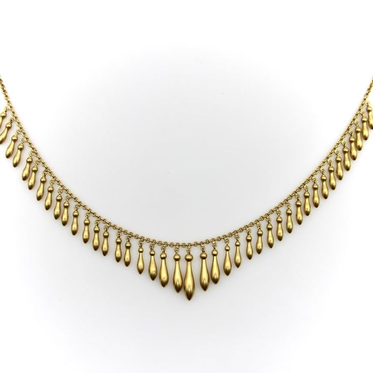 This is part of Chairish’s Fine Jewelry assortment.  This 14k gold fringe necklace encapsulates the essence of romantic jewelry from the Victorian era. Graduated elongated drops topped with round spheres dangle from the 15” necklace. The gorgeous surface of the gold is what is known as a bloom finish--a technique used in the Victorian era to dip gold jewelry into acid to burn off all other metals near the gold’s surface. While this necklace is 14k gold, the outside layer is closer to 20k and gives off the warm buttery glow of a high karat gold. What we love about fringe necklaces is their lovely movement that catches the light so beautifully.   The necklace measures 15”, and the drops range in size from 7/8” to 1/2”. The piece weighs 20.5 grams. It is in near perfect condition, with a barr Elegant Yellow Gold Necklaces With Dangling Beads, Elegant Teardrop Dangling Beads Necklaces, Elegant Teardrop Necklace With Dangling Beads, Elegant Teardrop Necklaces With Dangling Beads, Elegant Teardrop Dangling Beads Necklace, Victorian Gold Necklace With Antique Finish, Victorian Gold Choker Necklace, Victorian Gold Rectangular Necklace, Victorian Antique Finish Gold Necklace