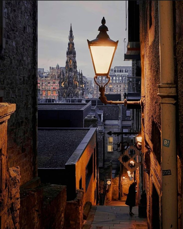 an alley way with a street light and buildings in the background