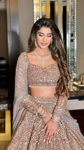 a woman in a gold and silver outfit standing next to a mirror with her hands on her hips