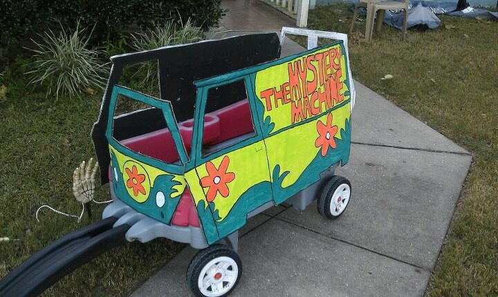 a small cart that has been painted with flowers and words on the side, sitting in front of a house