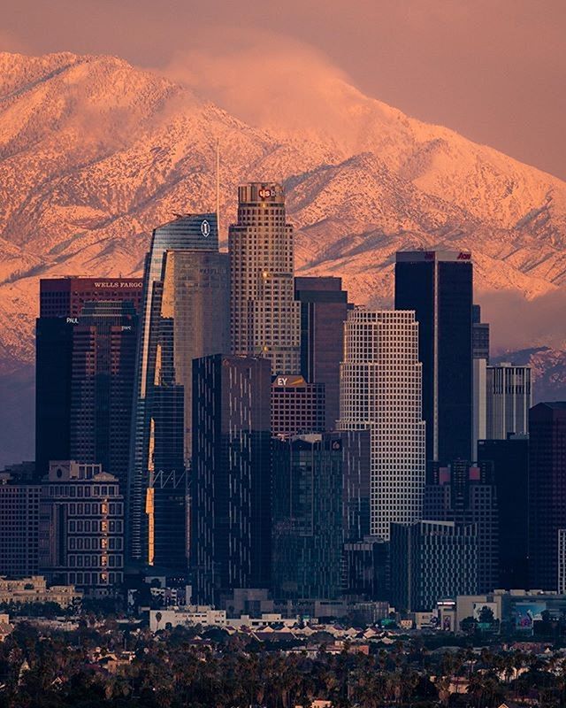 a city with mountains in the background and snow on the top part of the mountain