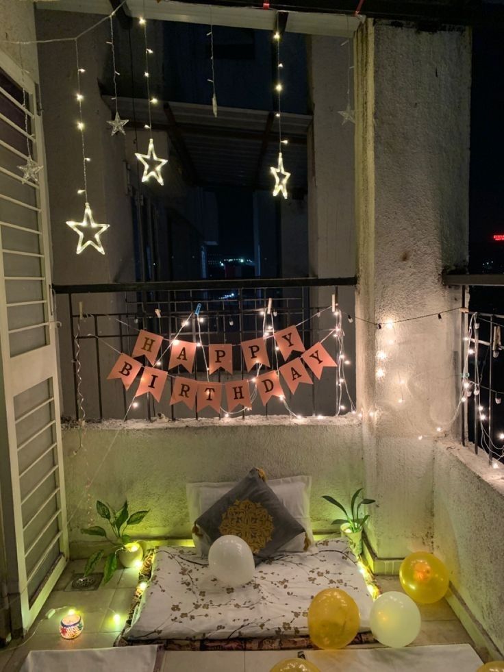 a balcony decorated with lights and decorations for a birthday