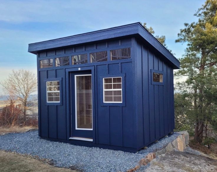 a small blue building sitting on top of a hill