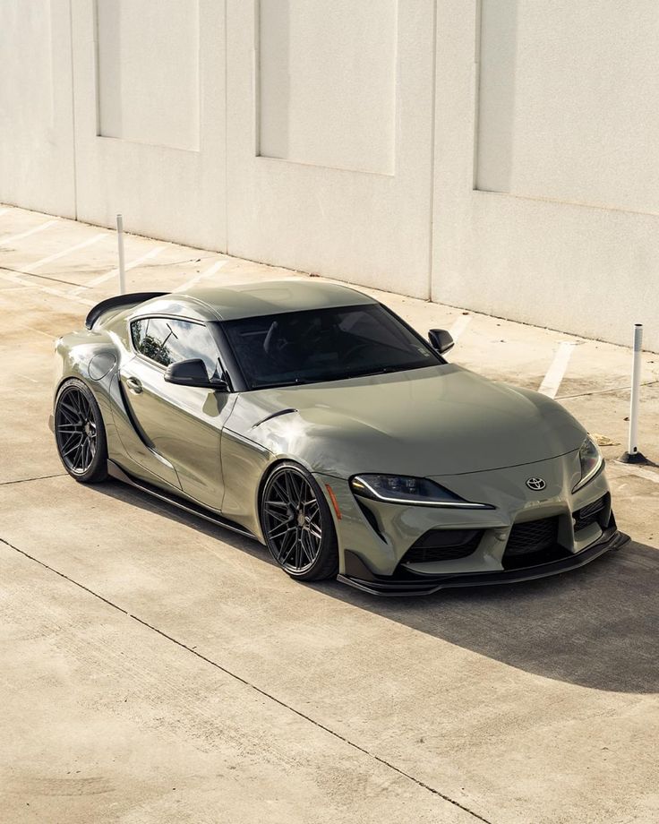 a gray toyota sports car parked in front of a building