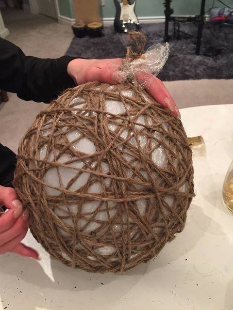 a person holding a ball made out of rope on top of a white tablecloth