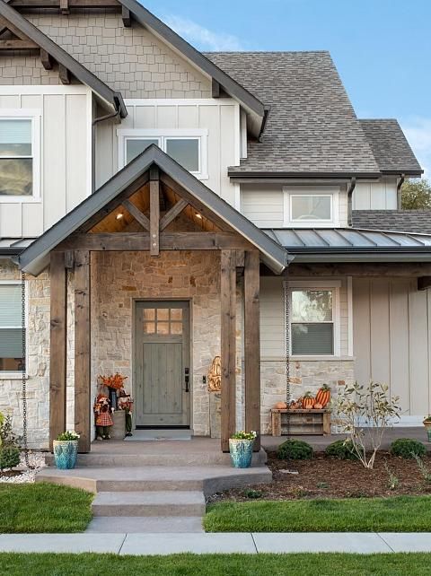 the front entrance to a home with two large windows and an entry way leading into it