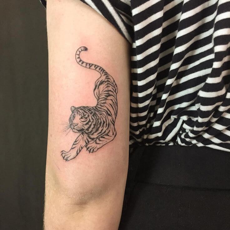 a woman's arm with a tiger tattoo on the left side of her arm