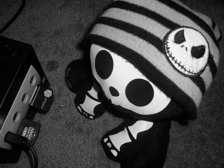 a black and white photo of a stuffed animal with a skull on it's head