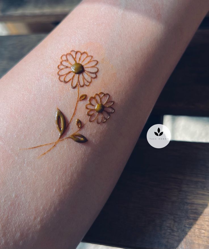 a close up of a person's arm with flowers painted on the side of it