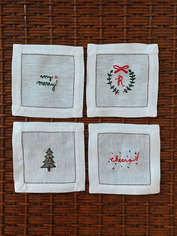 four embroidered napkins with christmas designs on them