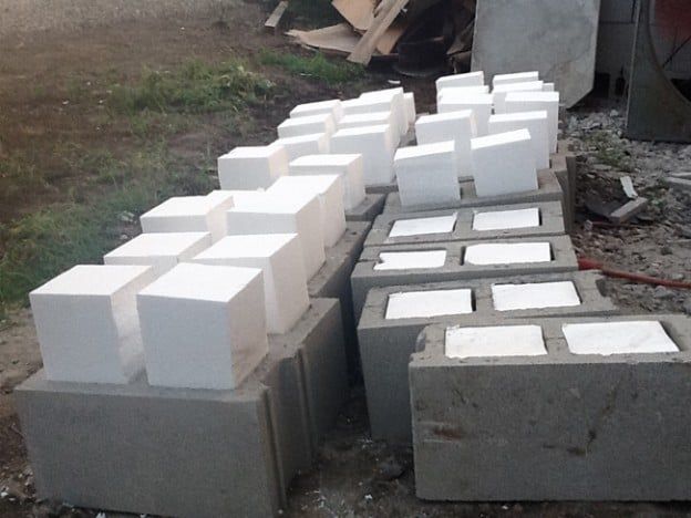 several cement blocks are stacked on top of each other in the middle of a yard