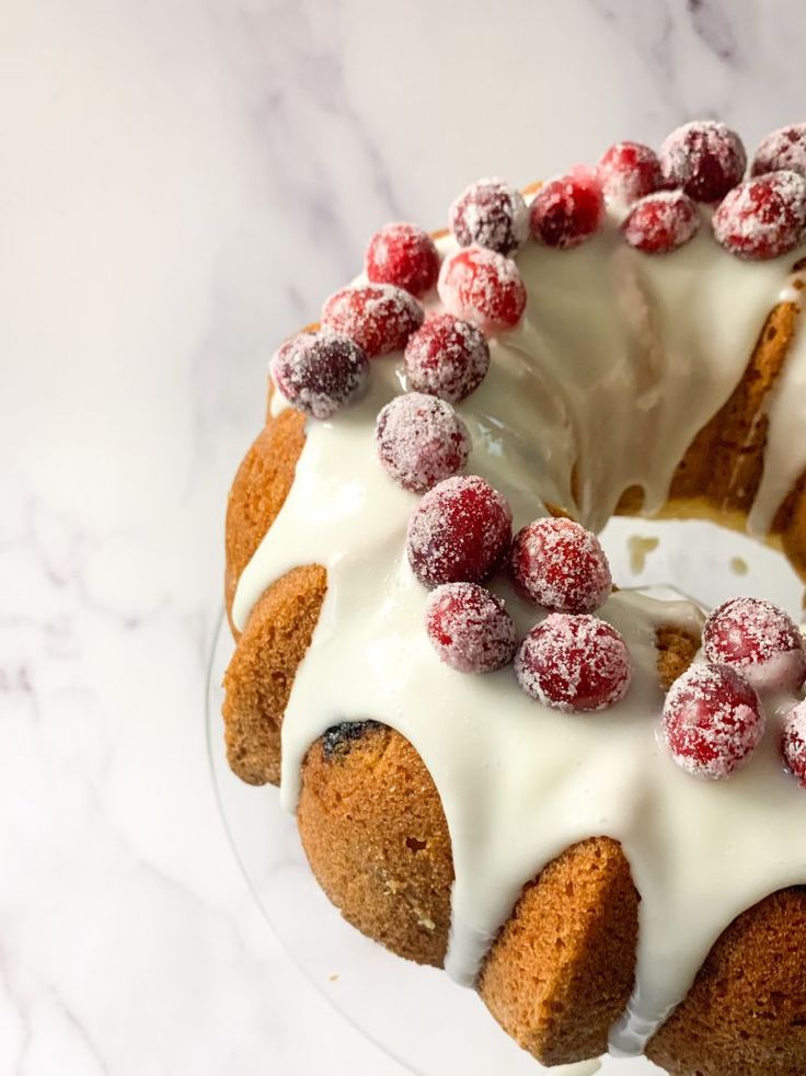 a bundt cake with icing and cranberries on top