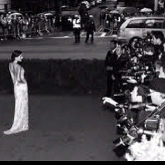 a black and white photo of a woman standing in front of a group of people