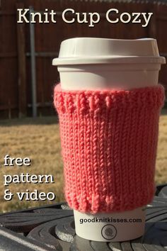 a knitted cup cozy sitting on top of a table next to a coffee cup