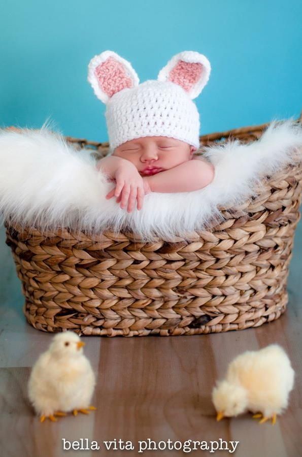 a baby is sleeping in a basket with two little chicks on the floor next to it