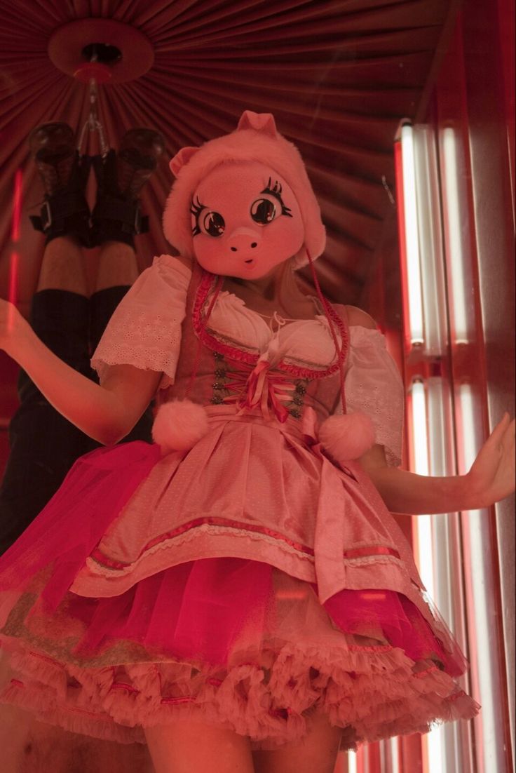 a doll dressed in pink is standing next to a mannequin