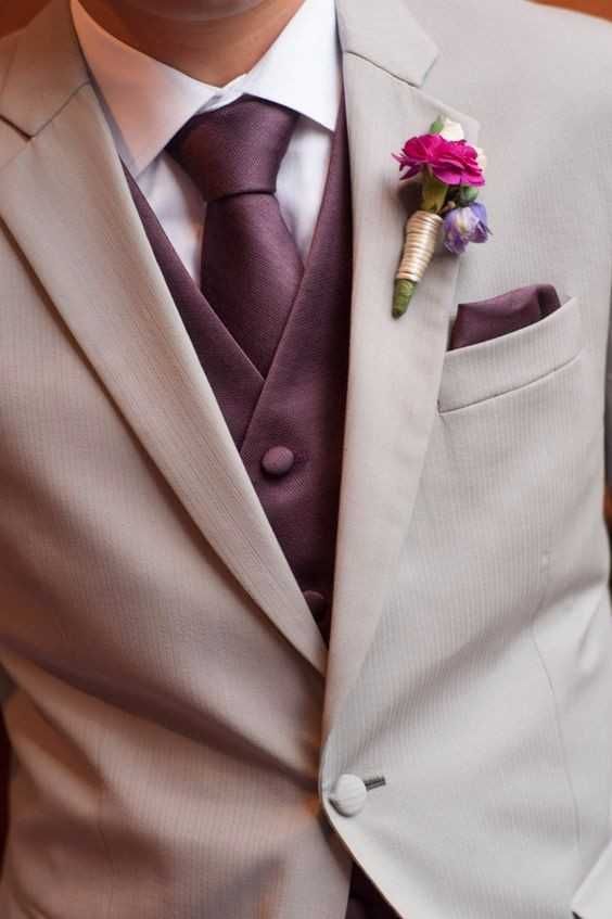 a man in a suit and tie with a boutonniere on his lapel