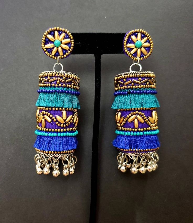 Fun and playful Afghani fringe earrings, with gold tone bead work. The perfect summer earring, colorful and carefree. Fabric backed ear stud ensures a comfortable fit. The main body is fabric wrapped around a metal cylinder. Beautiful vibrant colors. Little bells make a lovely sound when you move your head. Weight 21 gm. Find even more great earrings here: https://www.etsy.com/shop/boutiquebymaryam?section_id=22797814 Be sure to visit the rest of my shop here: https://www.etsy.com/shop/boutiqueb Blue Bohemian Earrings With Latkans, Bohemian Blue Earrings With Latkans, Blue Fringe Earrings For Festivals, Traditional Gold Beaded Tassel Earrings, Traditional Gold Beaded Earrings With Tassels, Blue Festival Earrings With Latkans, Blue Latkans Jewelry For Festival, Bohemian Blue Tassel Chandelier Earrings, Festive Multicolor Earrings