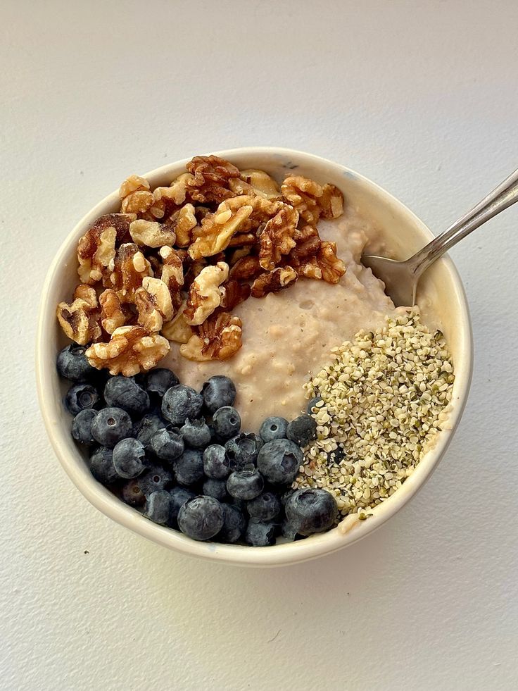 a bowl filled with oatmeal, blueberries and nuts