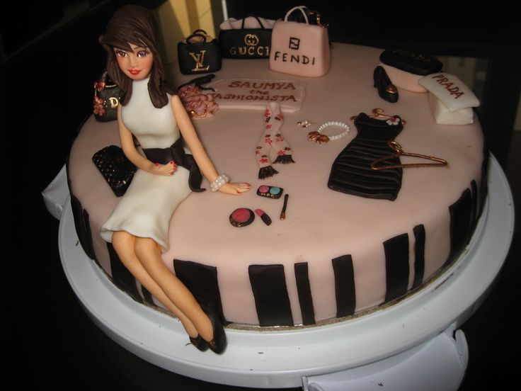 a cake decorated with a woman sitting on top of a piano keyboard and purses