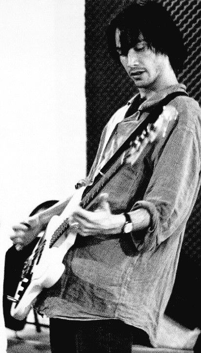 black and white photograph of a man playing an electric guitar