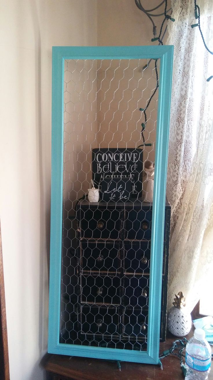 a blue framed mirror sitting on top of a wooden table