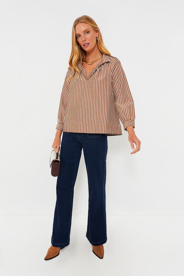 The Mocha Emy Top is exactly what we want in a blouse — effortless, elegant, and ultra-versatile. Made in a neutral colorway that pairs well with just about anything, this relaxed silhouette features a stand collar for an extra bit of elegance, as well as bracelet length raglan sleeves that allow you to accessorize and vertical stripes to elongate the body. Style it with trousers and slingback heels for an elevated office look, or go for denim and crisp white sneakers for weekend wear! Stand col Versatile Fall Blouse For Business Casual, Versatile Business Casual Blouse For Fall, Chic Brown Tops For Business Casual, Chic Brown Top For Business Casual, Chic Relaxed Fit Blouse With Split Neck, Brown Relaxed Fit Blouse For Fall, Chic Blouse With Split Neck And Relaxed Fit, Chic Split Neck Blouse With Relaxed Fit, Brown Collared Blouse With Relaxed Fit