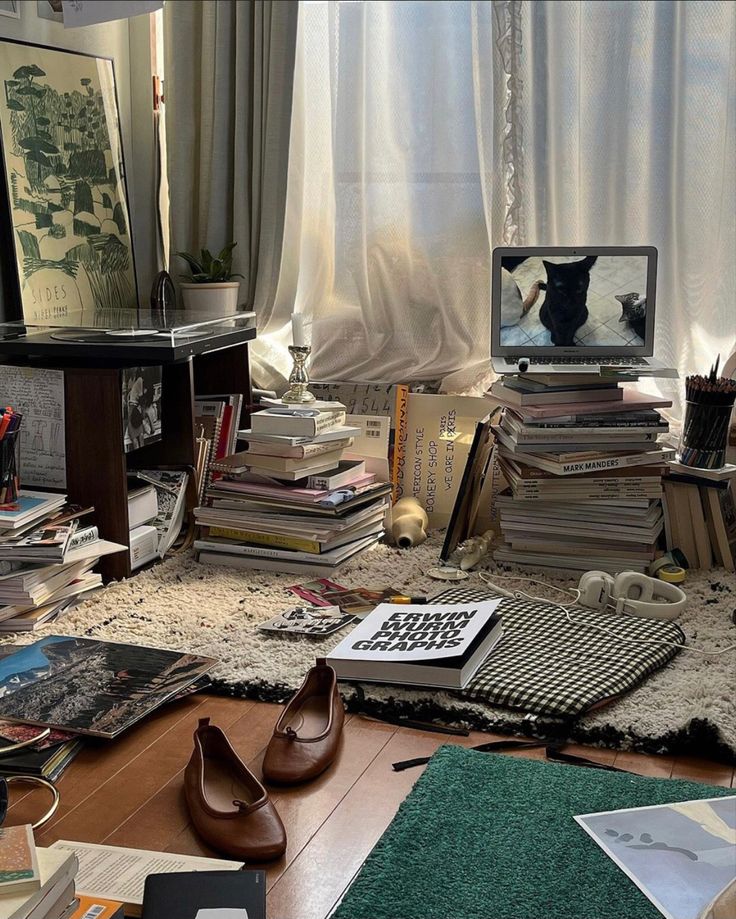 a pile of books sitting on top of a wooden floor next to a computer monitor