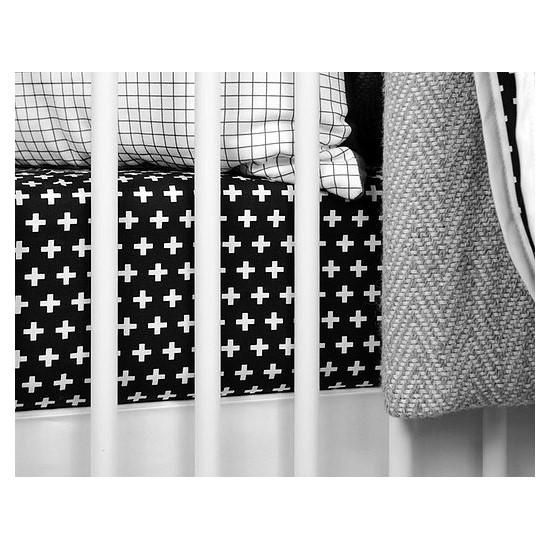 a black and white photo of a crib with blankets on it's sides