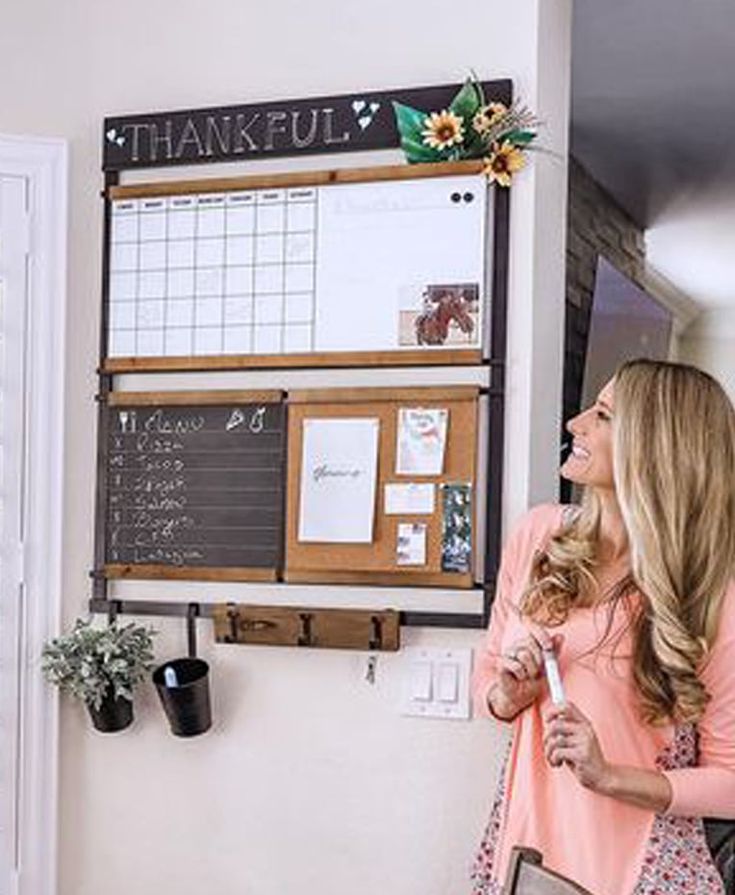 a woman standing in front of a chalk board