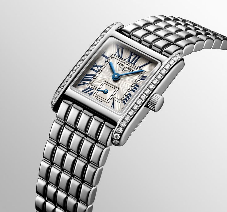 With its discreet profile, classic styling, and aesthetic variations that are at once timely and timeless, the Mini DolceVita is a small but mighty masterpiece that exquisitely expresses, in equal part, Longines’ quiet luxury and contemporary elegance. Each reference in the Mini DolceVita collection features a rectangular 21.50mm x 29.00mm stainless steel case and is powered by a highly-accurate L178 quartz movement. Model#: L5.200.0.71.6 Case: Stainless steel, 0.456ctw diamonds Water Resistance: 3 bar Dial: Silver "flinqué", blue steel hands Movement: Quartz Strap: Stainless steel Luxury Quartz Watches With Rectangular Dial, Luxury Blue Rectangular Watch, Modern Luxury Silver Watch, Luxury Modern Silver Jewelry And Watches, Luxury Silver Watch With Rectangular Dial, Luxury Quartz Watch With Rectangular Dial, Luxury Modern Diamond Watch With Rectangular Dial, Luxury Classic Rectangular Watch Accessories, Luxury Modern Quartz Watch