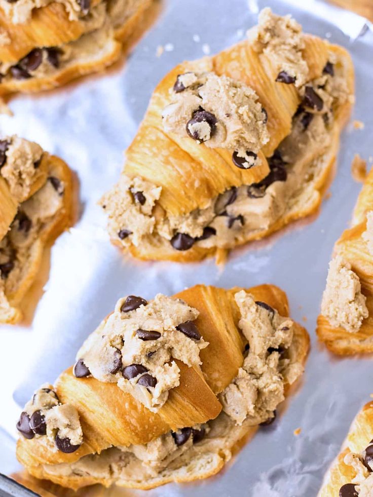 several croissants filled with chocolate chip cookies on top of a baking sheet