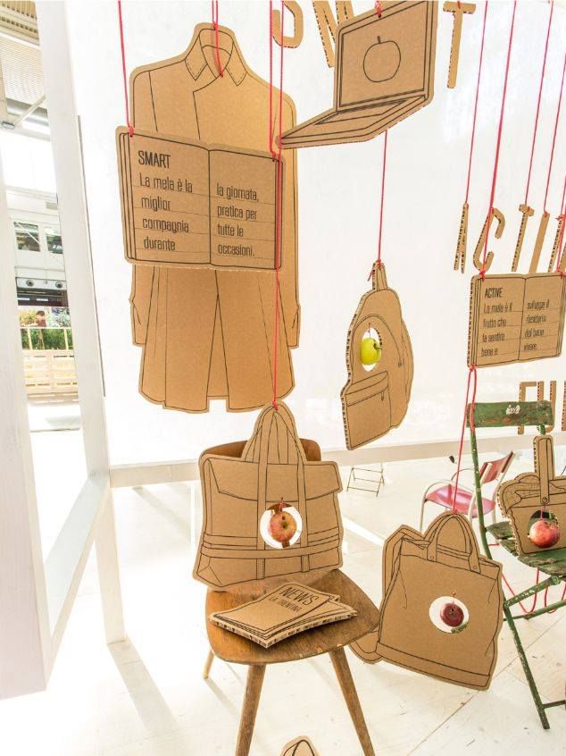 cardboard cutouts are hanging from strings in front of a display with bags and purses