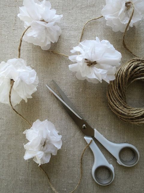 scissors and twine are sitting on the table next to some white paper flower decorations