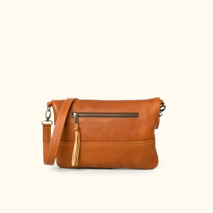 This is a true statement: Every woman loves options. That’s why we designed our Madison Crossbody Foldover Clutch. It’s the option when you simply want to carry a few necessary items and need a dependable bag to do it. The adjustable, removable strap feature allows you the option of adjusting the length of the bag during the day then removing it effortlessly for an evening clutch. The exterior zippered pocket holds those items you need easy access to, and the interior open pocket gives you the o Brown Flap Saddle Bag With Adjustable Strap, Brown Crossbody Flap Bag With Adjustable Strap, Elegant Brown Crossbody Flap Bag, Brown Crossbody Saddle Bag, Classic Dark Tan Shoulder Bag With Adjustable Strap, Cognac Crossbody Flap Bag With Removable Pouch, Brown Flap Bag With Adjustable Strap, Brown Flap Shoulder Bag For On-the-go, Brown Flap Bag For Everyday Use