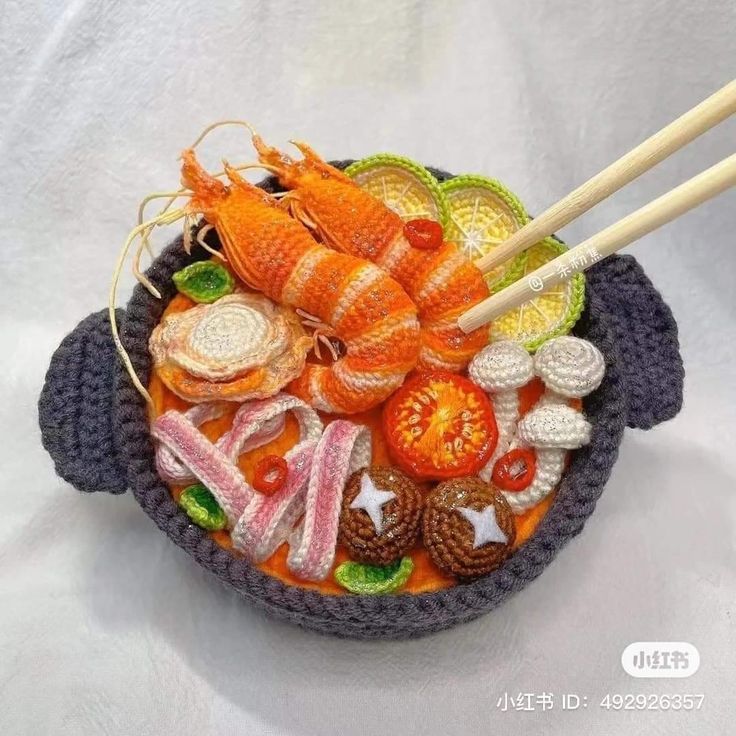 a crocheted bowl filled with food and chopsticks on top of it