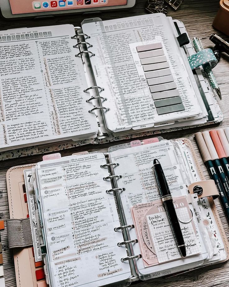 two open notebooks sitting on top of a wooden table