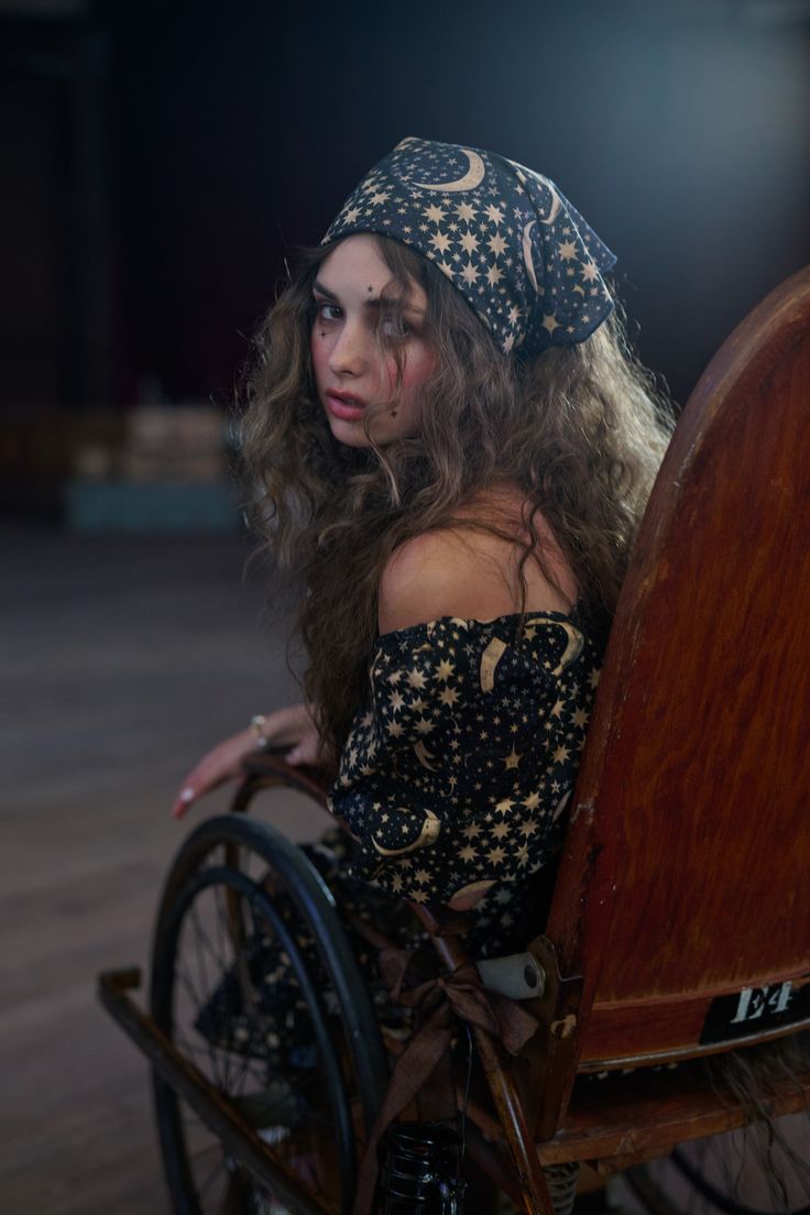 a woman sitting in a wheel chair with long hair